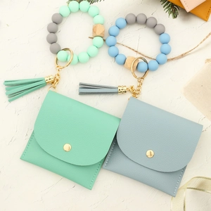 Detail of mint green and blue silicone bead keychains with textured PU leather wallets