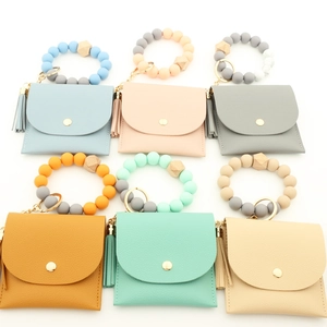 Detail of silicone bead wristlet with leather card holder and tassel in pastel colors