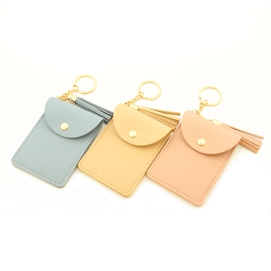 Detail of faux leather card holder keychains with tassel and gold-tone hardware
