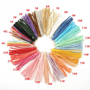 Vue détaillée de 25 pompons en suédine colorés avec anneaux dorés pour bricolage