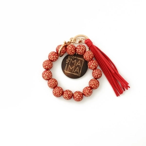 Détail du porte-clés en perles de bois léopard rouge avec étiquette MAMA et pompon rouge