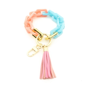 Détail du porte-clés en acrylique coloré avec maillons bleu rose et pompon en cuir