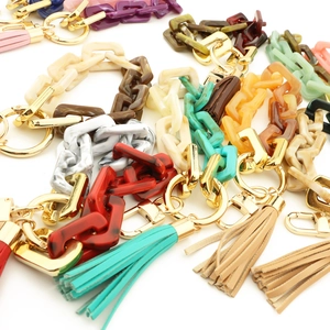 Porte-clés en chaîne acrylique colorée avec pompons et attaches dorées en divers motifs vifs
