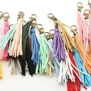 Gros plan de porte-clés à pompons multicolores en similicuir avec fermoirs en bronze
