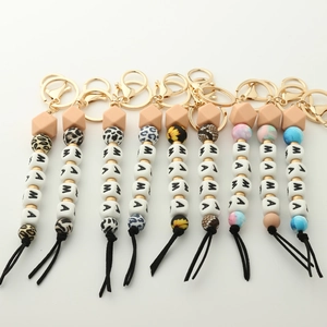 Detail view of MAMA silicone bead keychains with leopard and floral patterned charms