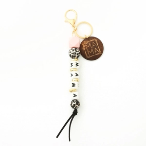 Detail of MAMA silicone bead keychain with leopard print accents and wooden tag