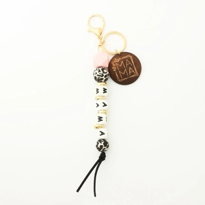 Detail of beaded keychain with MAMA letters, silicone beads, wood disk, and black tassel