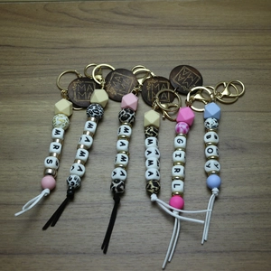Close-up of silicone bead keychain with engraved MAMA wood disc and stylish tassel