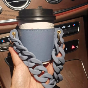 Blue leather coffee cup holder with matching chunky matte chain handle in car interior