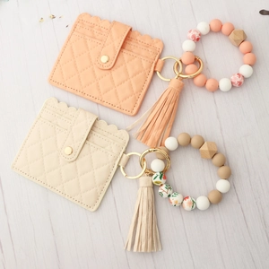 Detail of quilted leather card holders with beaded wristlet and elegant leather tassels