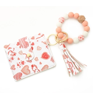 Detail of pink heart printed card wallet with silicone beaded wristlet and gold hardware