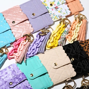 Detail of colorful PU leather card holders with quilting, tassels and gold metal clasps