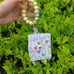 Detail of floral wallet card holder with silicone bead bracelet keychain and tassel charm