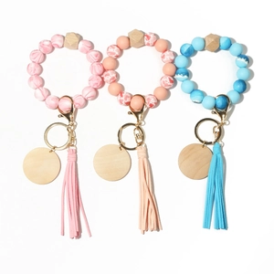 Three sets of silicone bead keychain bracelets with marble patterns and wooden charms