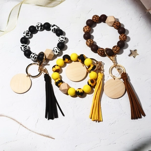 Detailed view of silicone bead wristlet keychains with cow, sunflower, and leopard prints