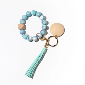 Macro shot of marble-textured silicone beads keychain with wood disk and mint green tassel