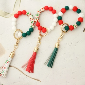 Close-up of Christmas silicone beaded keychains with Santa prints and faux leather tassels