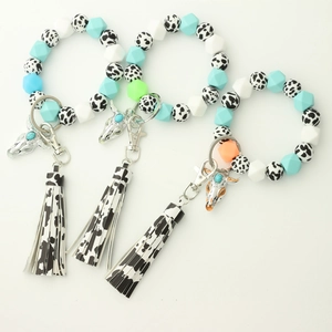 Détail du bracelet en perles de silicone lumineuses avec breloque tête de vache et gland