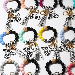 Dettaglio di bracciali portachiavi in perline di silicone con nappe e ciondoli Mama