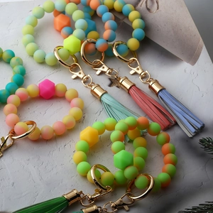 Macro view of colorful glowing silicone bead bracelets with tassels and gold alloy clasps