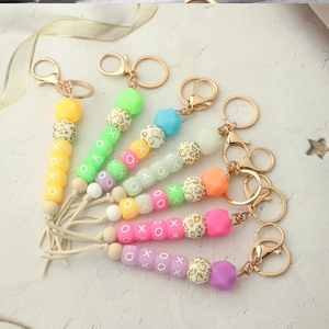 Detail of colorful macaron silicone beads keychain with XOXO pattern and leather tassel