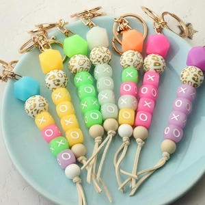 Macro shot of colorful silicone beaded keychain with XOXO letter beads and suede tassel