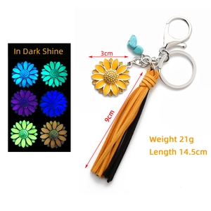 Luminous sunflower keychain with leather tassel showing colorful glow effect in the dark