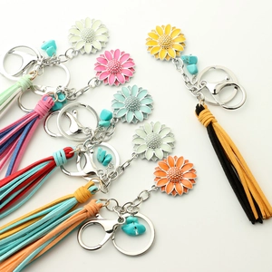 Luminous sunflower keychain with colorful tassels and enamel charms on a white background
