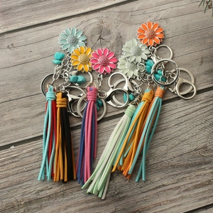 Close-up of colorful sunflower keychains with suede tassels on rustic wood