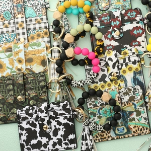 Detail of silicone bead keychain wallet sets featuring cow print and western floral patterns
