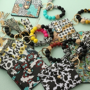 Detail of faux leather card holder with silicone bead wristlet and tassel keychain
