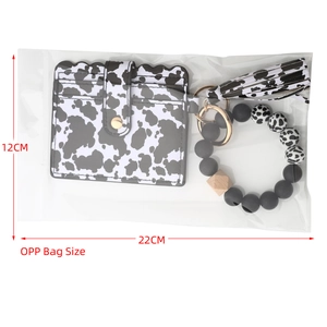 Detail of cow print card holder and beaded keychain set with tassel in packaging