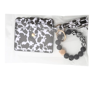 Detail of cow print card holder and silicone bead wristlet keychain in transparent bag