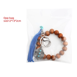 Bohemian wood bead keychain with blue tassel and leaf charm in a clear OPP bag