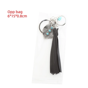 Detail view of Bohemian alloy leaf keychain with turquoise beads and long black tassels