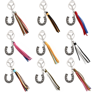Detail view of horseshoe keychains with assorted colorful suede tassels in nine variations