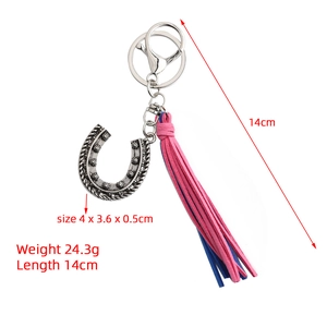 Detail view of vintage silver horseshoe keychain with pink and blue tassels, 14cm length