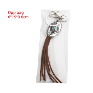 Detail of bohemian silver hollow pendant with turquoise stone and brown leather tassel
