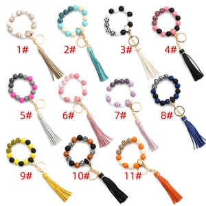 Détails de 11 porte-clés en perles avec pompons en cuir et motifs d'animaux variés