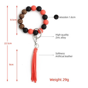 Dettaglio del portachiavi a bracciale con perline arancioni, maculato e nappa in pelle