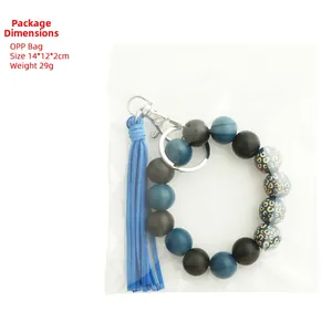 Dettaglio del portachiavi con perline di legno, motivo leopardato e nappa in pelle blu