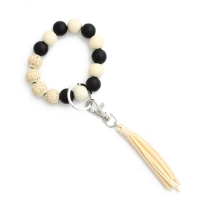 Dettaglio del bracciale portachiavi con perle di silicone maculate, nappa e chiusura in metallo