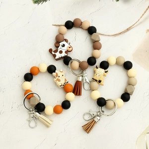 Porte-clés bracelet en perles de silicone avec pendentif vache et pompon en daim