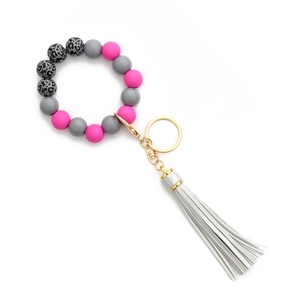 Détail du bracelet porte-clés perles avec perles gris rose et pompon blanc en cuir