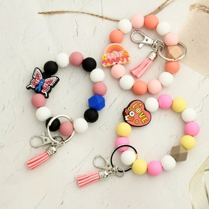 Bracelet porte-clés en perles de silicone avec pompon et breloque papillon arc-en-ciel