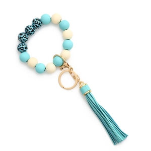 Détail du porte-clés bracelet perlé avec motif léopard bleu, fermoir doré et gland
