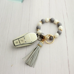 Detailed view of grey and marble silicone bead keychain with gold ring and tassel