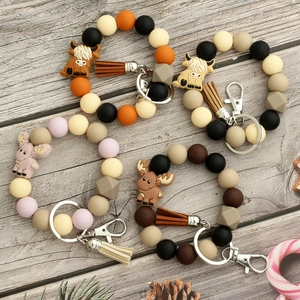 Détail de porte-clés en perles de silicone avec breloques animaux et glands en cuir