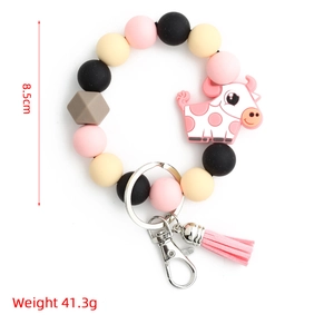 Détail du porte-clés en perles de silicone avec pendentif vache et décor de gland rose