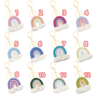 Matrix display of twelve colorful handmade macrame rainbow keychains with gold metal clasps